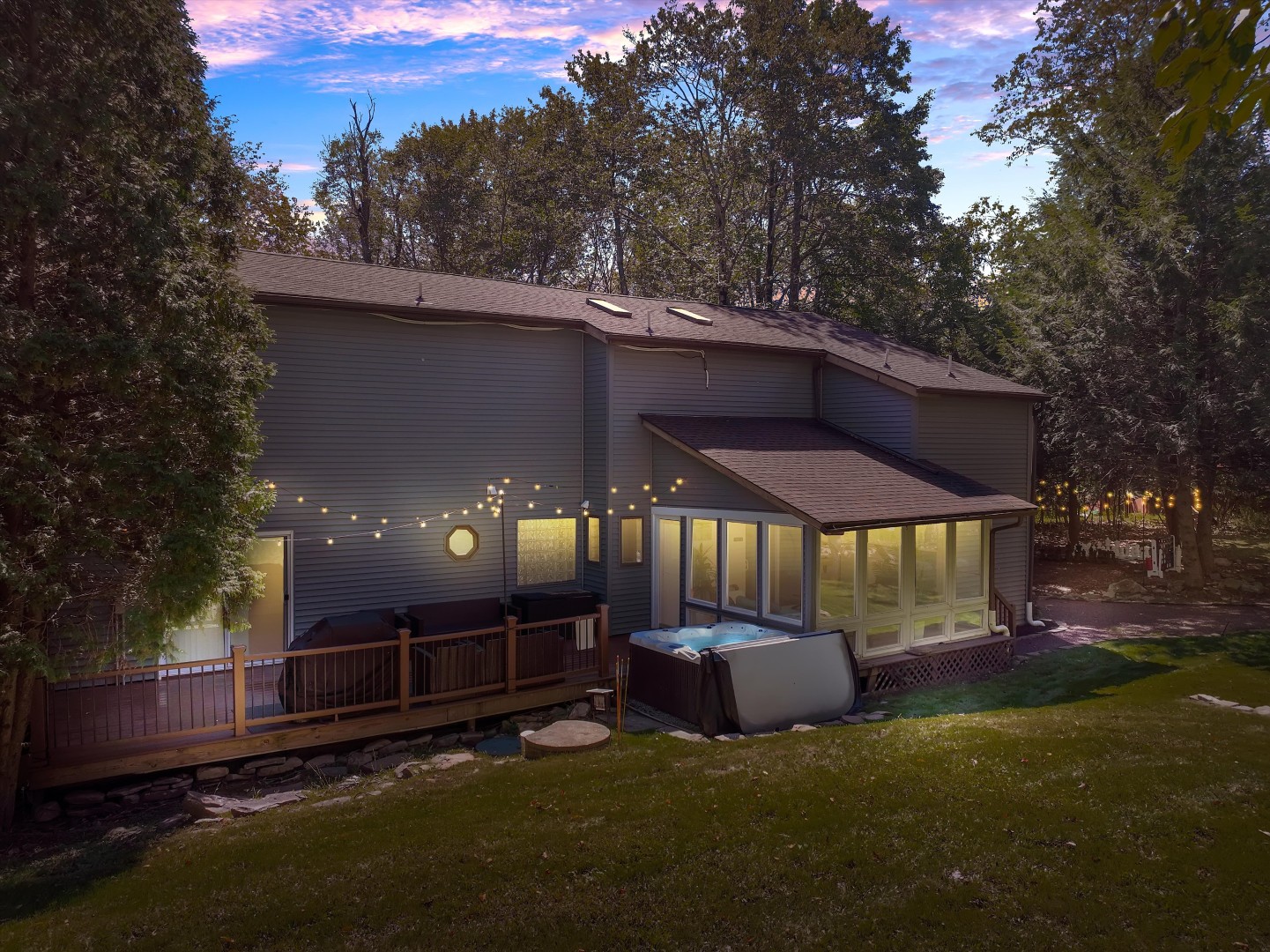 Soak in the private hot tub under warm festoon lights while taking in the quiet woodland backdrop of the Poconos.