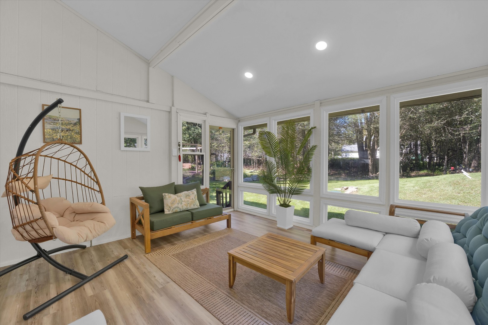 Relax in this spacious sunroom, where you can unwind in the cozy hanging chair or gather with loved ones to enjoy the serene views.