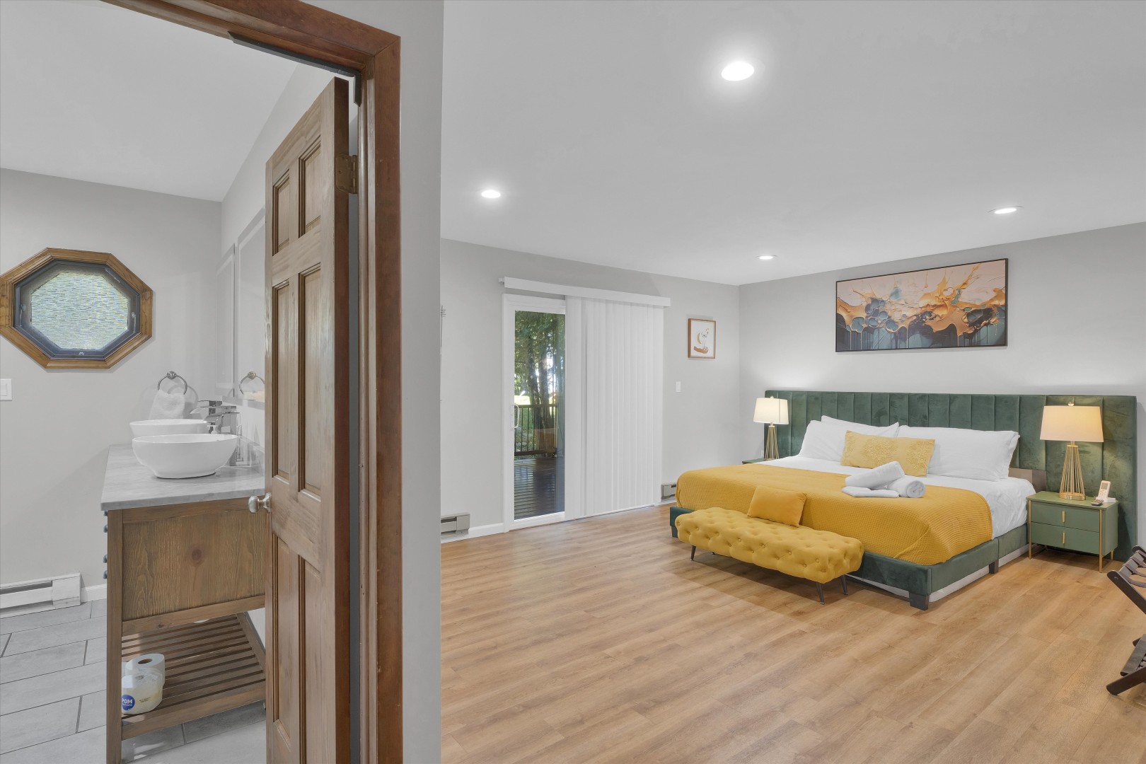 Light-filled bedroom entryway leading to comfortable king-size bedding and patio views.
